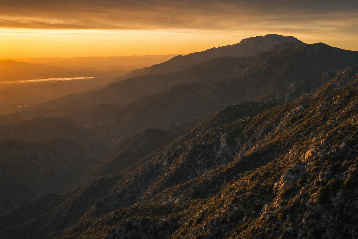 The San Bernardino Mountains above the valley at dusk, chaparral slopes in shadow.
