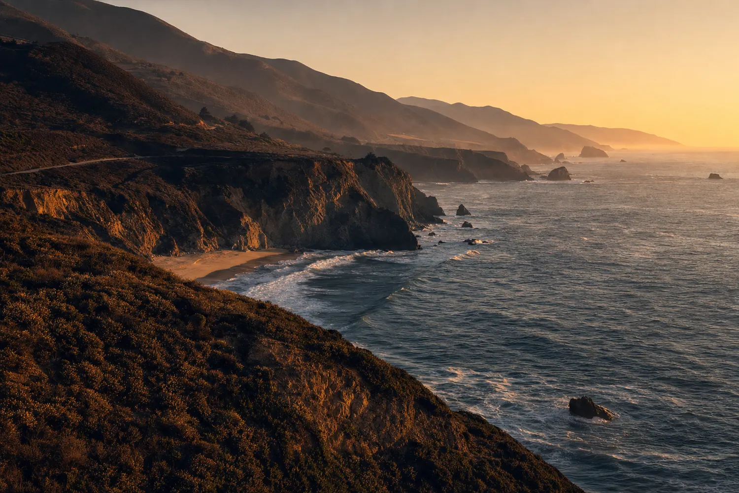 The rugged Pacific coastline of California, cliffs dropping to surf, coastal scrub on the headland.