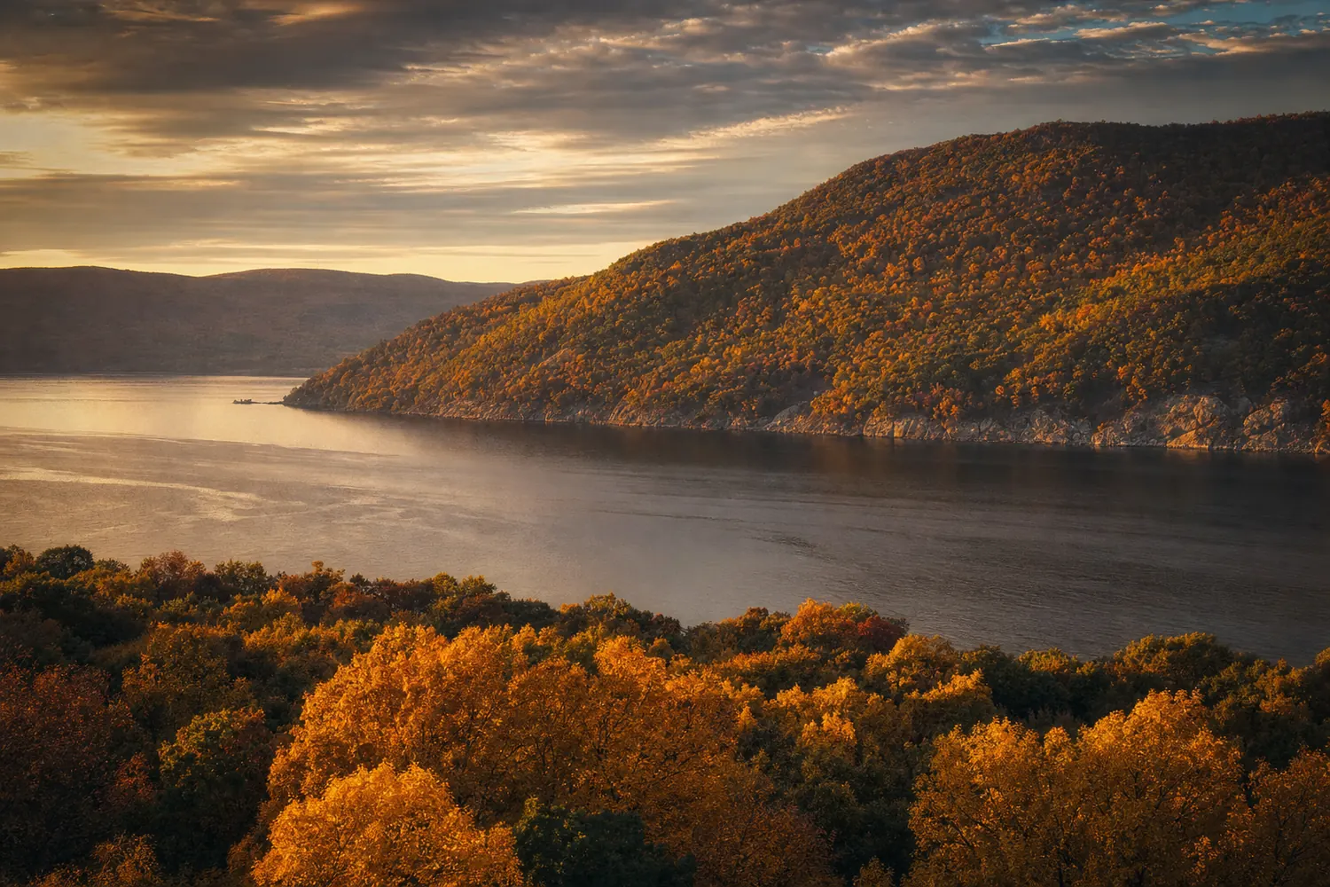 The Hudson Valley in New York, wooded hills in full autumn colour above a wide river.